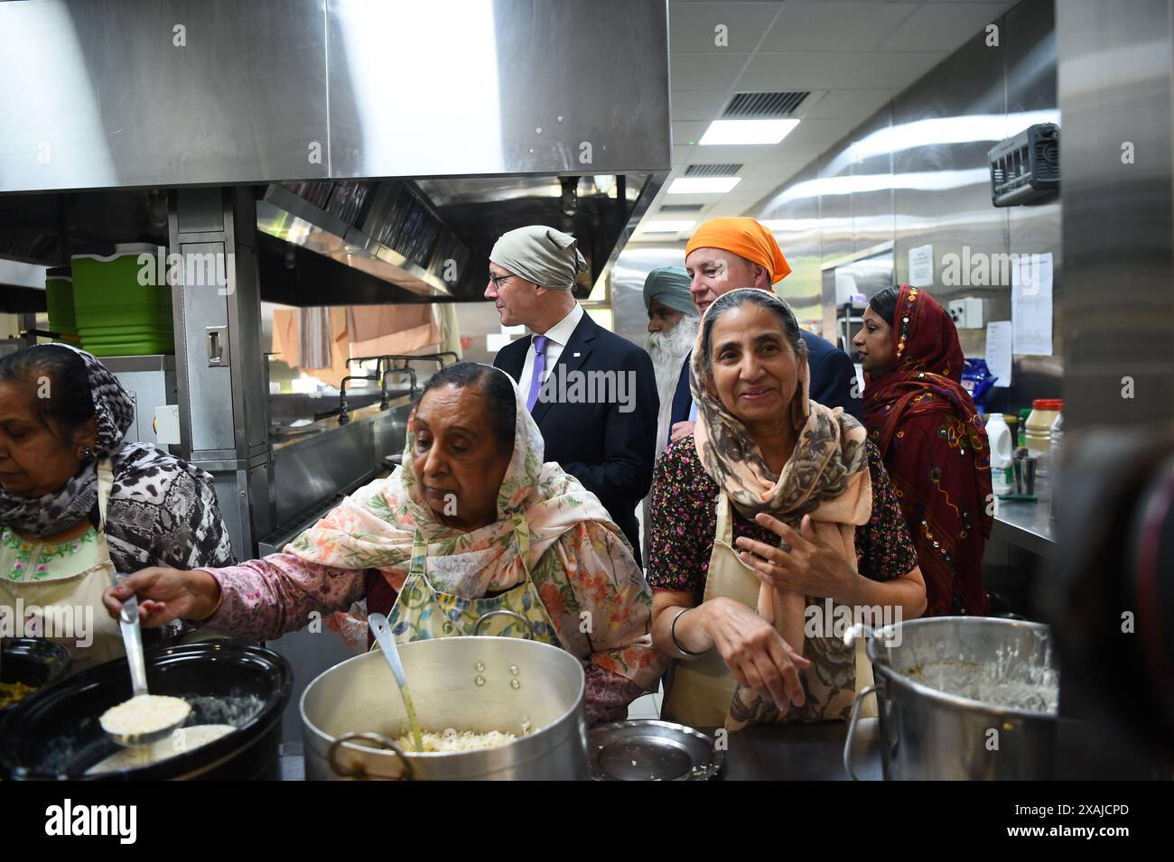 SNP-Chef John Swinney und Parlamentskandidat Chris Stephens werden die Küchen während seines Besuchs in Glasgow Gurdwara gezeigt, während er sich auf dem Wahlkampfpfad der Wahl befindet. Bilddatum: Freitag, 7. Juni 2024. Stockfoto