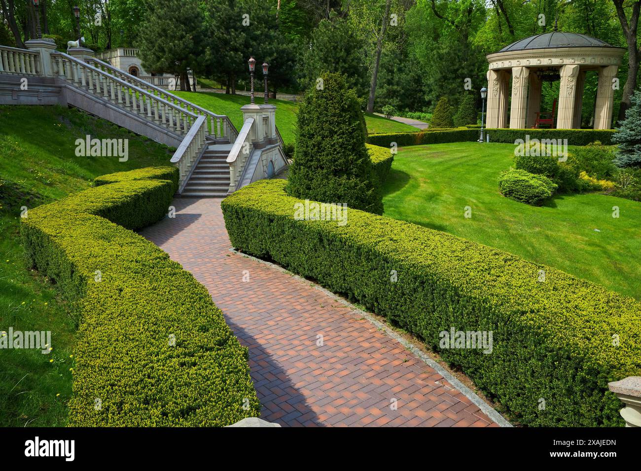 Der Hinterhof des Gebäudes mit Stufen und Eingang vor dem wächst Sträucher von immergrünen arborvitae mit einer quadratischen Form getrimmt, Fußgänger pa Stockfoto