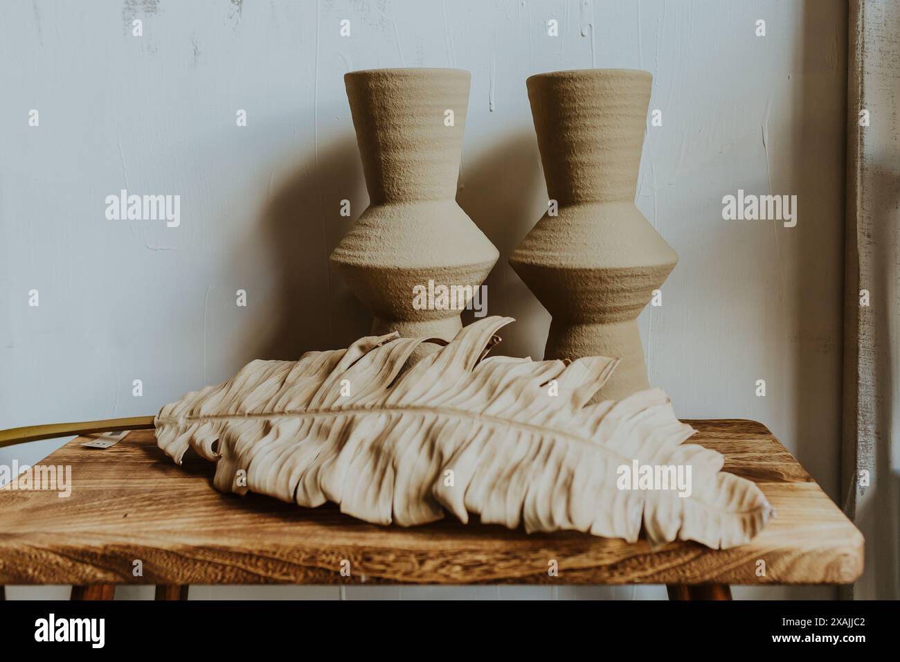 Zwei Vasen auf einem Holztisch mit trockenem Palmblatt Stockfoto