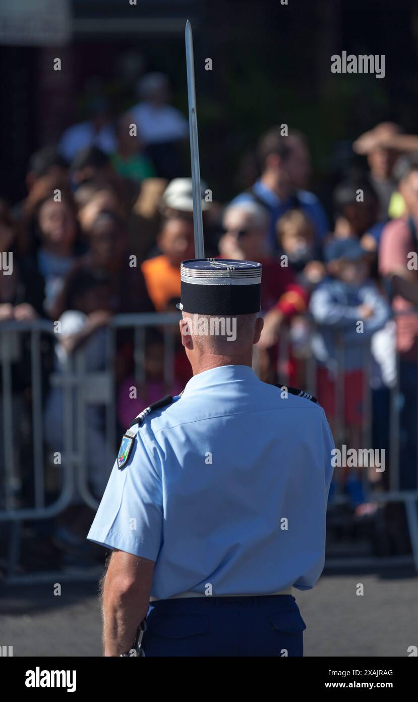 Kommandant der Gendarmerie mit seinem Schwert, der die Menge während der Parade des Bastille Day grüßt. Stockfoto