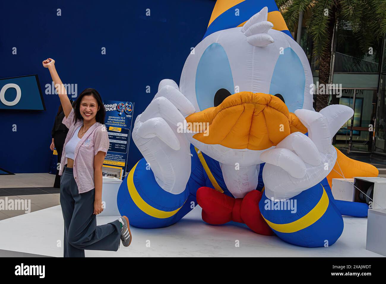 Bangkok, Thailand. Juni 2024. Eine Frau posiert für ein Foto vor einem Ballon von Donald Duck während des 90. Jahrestages der Disney-Figur „Donald Duck“ im Einkaufszentrum Siam Paragon. Donald Duck ist eine Zeichentrickfigur von Walt Disney, die 1934 das Filmdebüt gab. Quelle: SOPA Images Limited/Alamy Live News Stockfoto