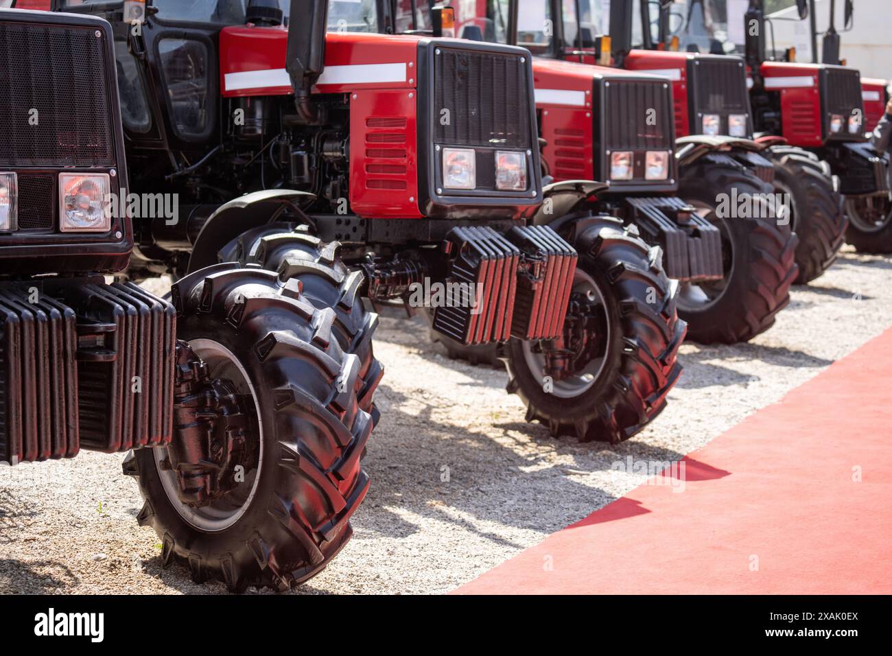 Reihe roter landwirtschaftlicher Traktoren zum Verkauf. Stockfoto