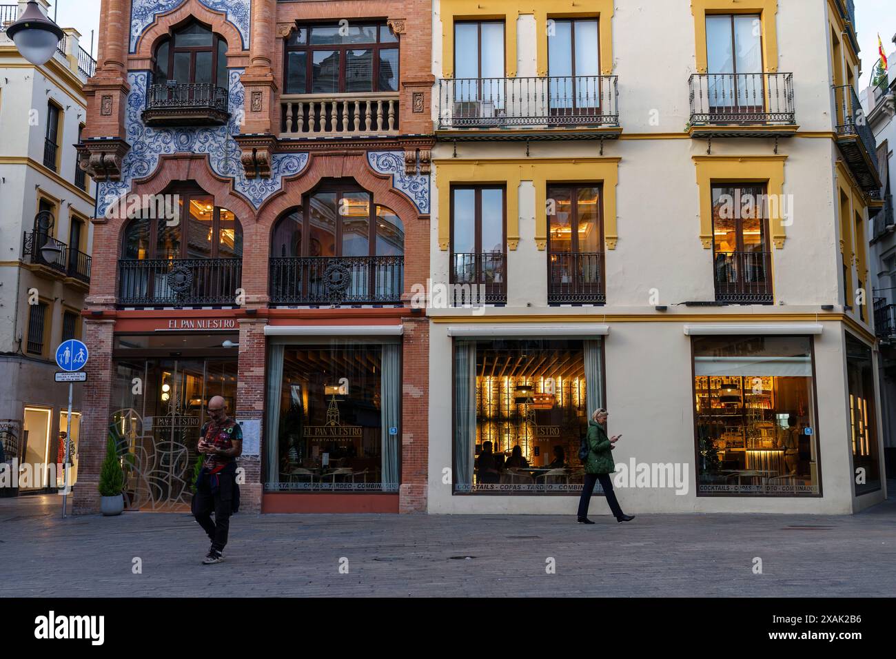 Sevilla, Spanien. Februar 2024. Leute gehen vor das Restaurant El Pan Nuestro im historischen Pedro Roldan Gebäude Stockfoto