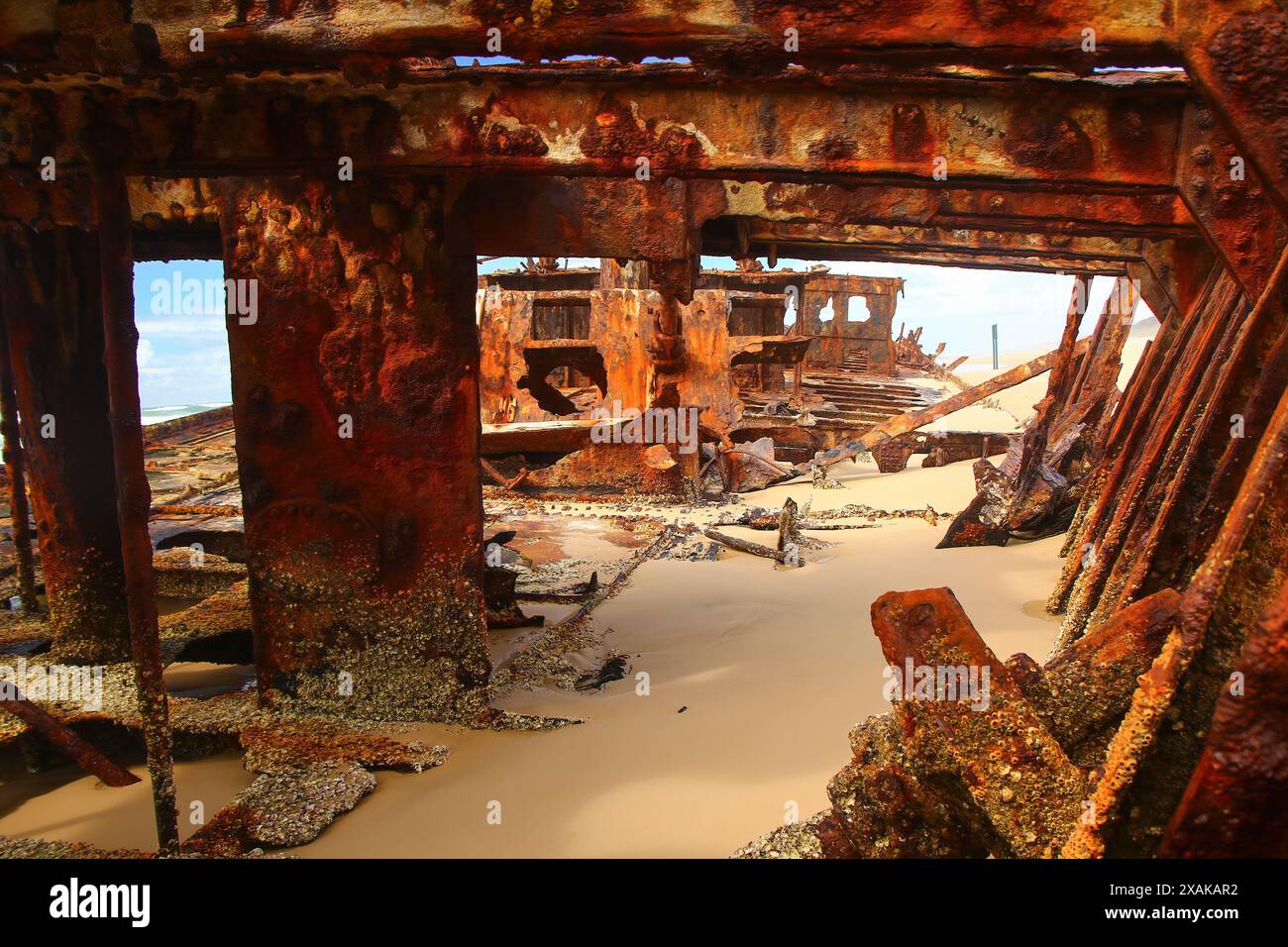 Rostiges, zerbröckelndes Stück des SS Maheno Schiffswracks, halb im Sand des 75 Meilen langen Strandes an der Ostküste von Fraser Island in Queensland, Austra, begraben Stockfoto