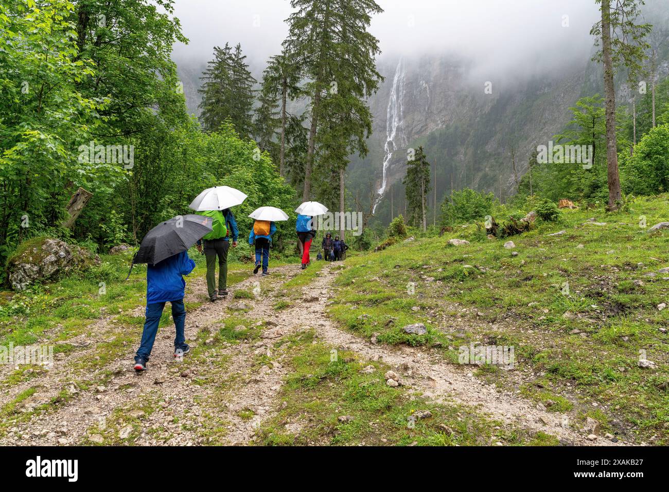 Europa, Deutschland, Bayern, Bayerische Alpen, Berchtesgaden, Wandergruppe mit Sonnenschirmen auf dem Weg zu den Röthbachfällen Stockfoto