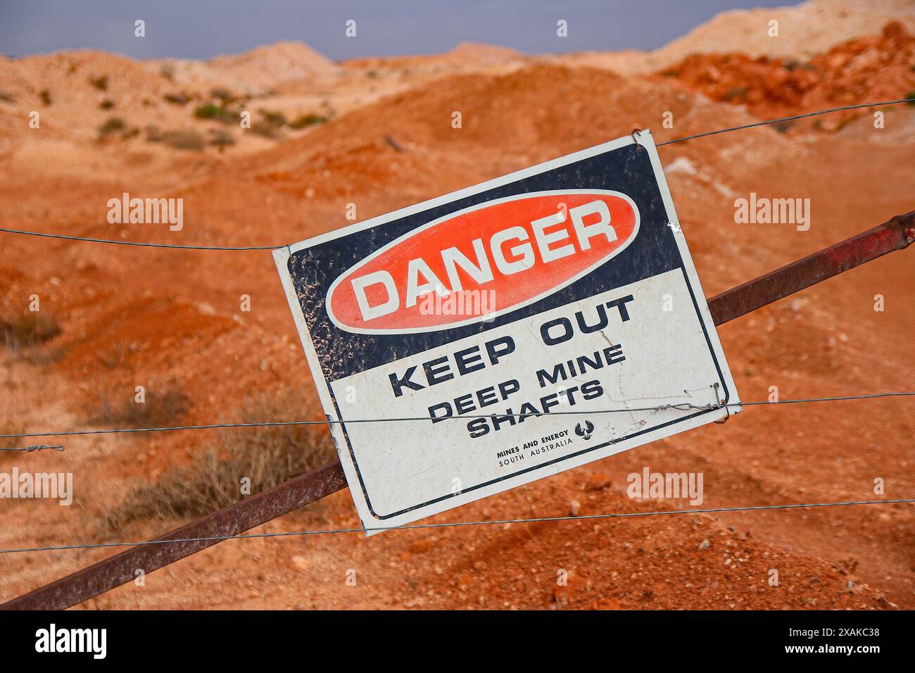 Gefahrenschild vor Toms arbeitender Opal-Mine in Coober Pedy, South Australia - Warnung vor tiefen Minenschächten in der australischen Wüste Stockfoto