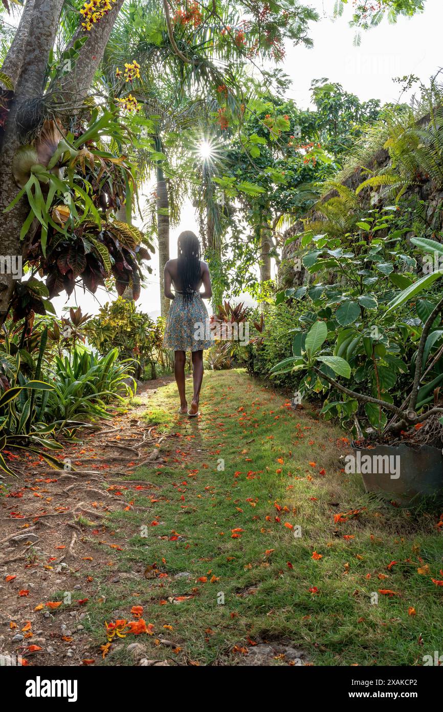 Nordamerika, Karibik, Hispaniola Island, Dominikanische Republik, Samana-Halbinsel, Sanchez, Jardines La Loma, hübsche dunkelhäutige Latina schlendert entlang eines Pfades in tropischer Vegetation Stockfoto