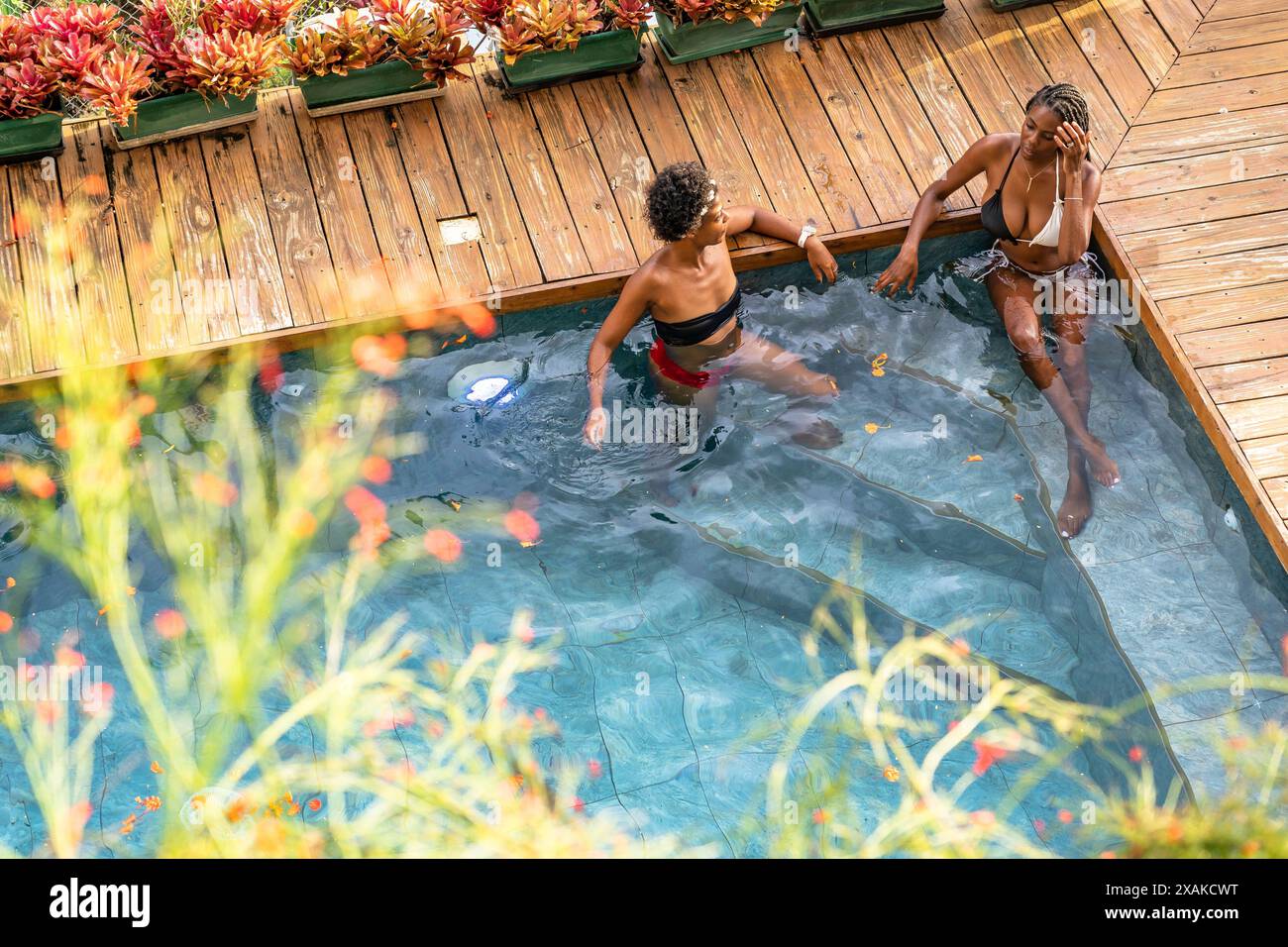 Nordamerika, Karibik, Hispaniola Island, Dominikanische Republik, Samana-Halbinsel, Sanchez, Jardines La Loma, zwei attraktive Latinas, die sich im Pool unterhalten Stockfoto