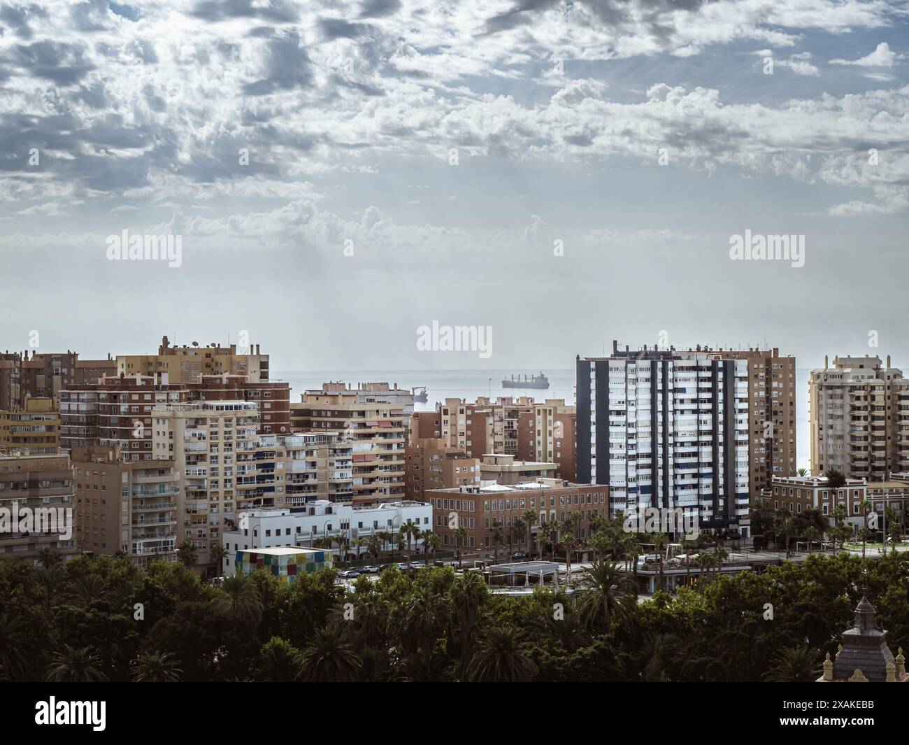 Skyline von Malaga mit Wohnungen Wohnhäuser im Sommer, mit dem Meereshorizont und einem Tankschiff im Hintergrund, Andalusien, Sp Stockfoto