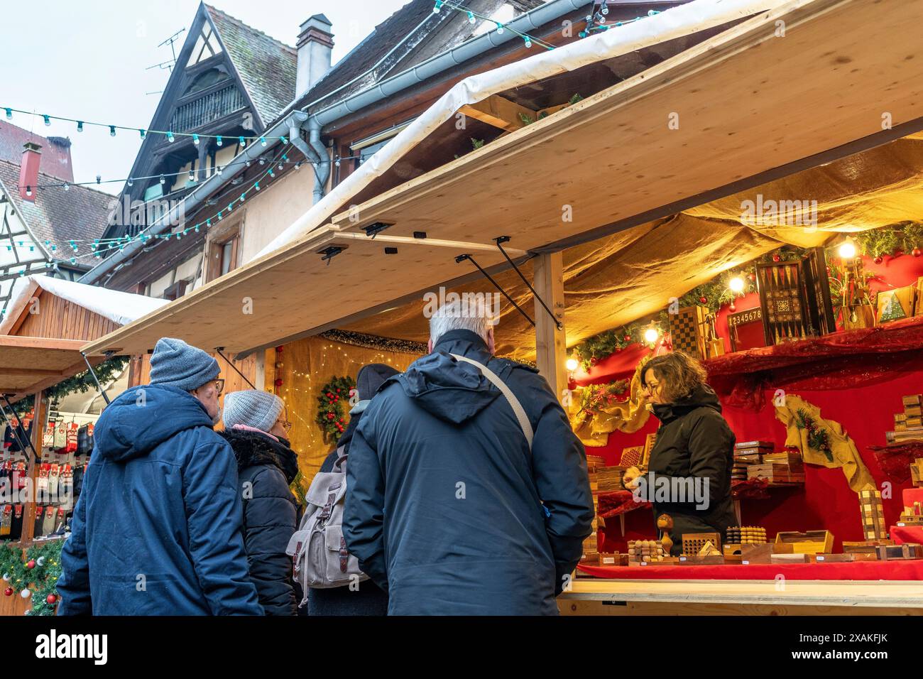 Europa, Frankreich, Grand Est, Elsass, Eguisheim, Touristen an einem Weihnachtsmarkt-Stand Stockfoto