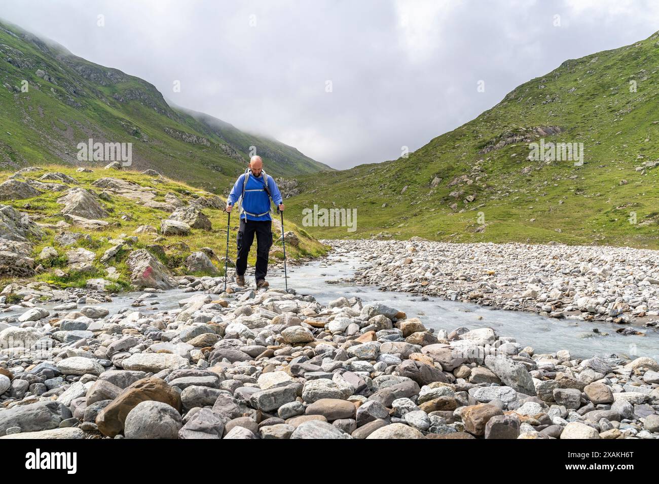 Europa, Österreich, Verwall, Tirol, St. Anton am Arlberg, Fasultal, Bergwanderer überqueren den Fasulbach im Fasultal Stockfoto