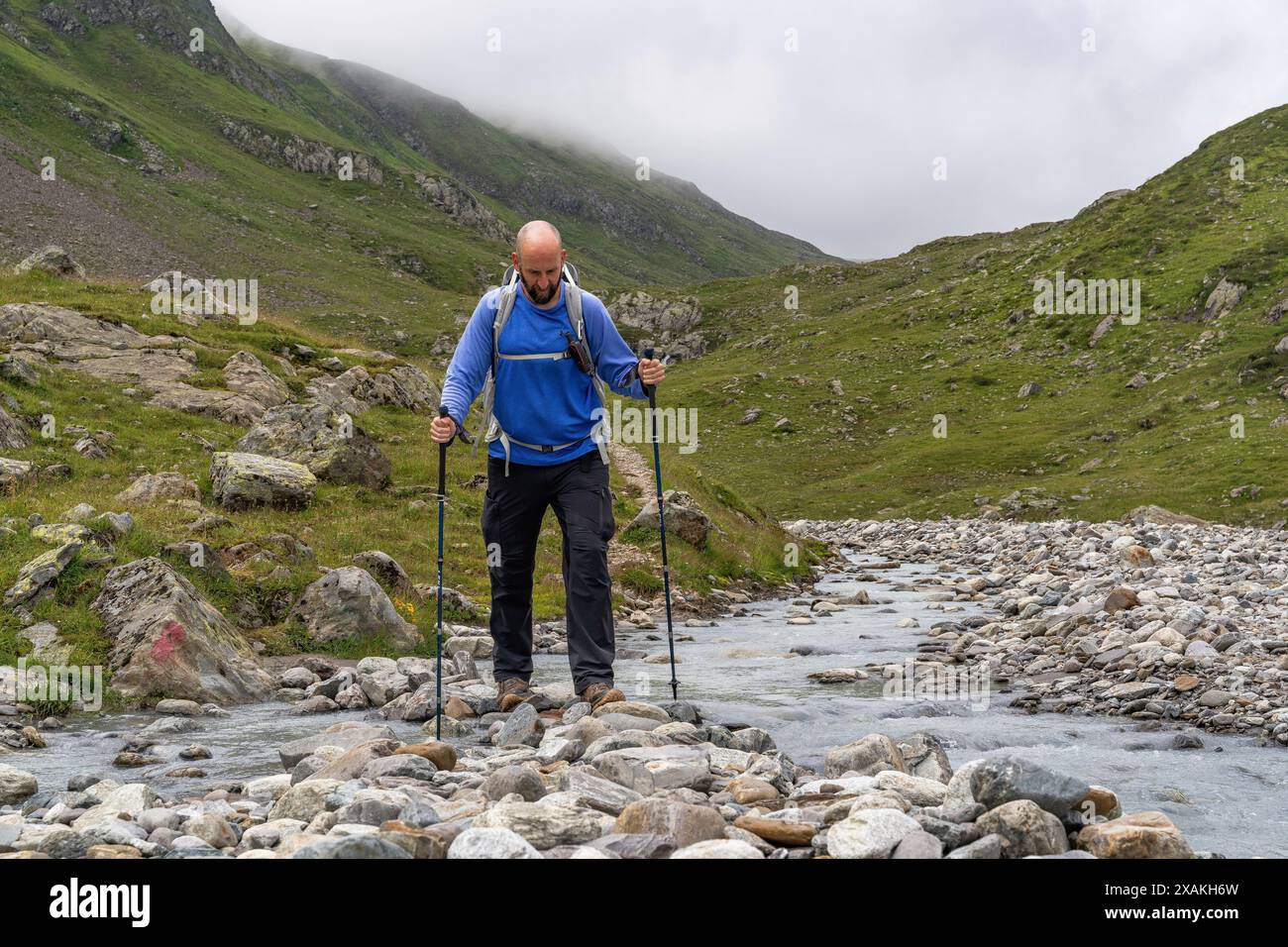Europa, Österreich, Verwall, Tirol, St. Anton am Arlberg, Fasultal, Bergwanderer überqueren den Fasulbach im Fasultal Stockfoto