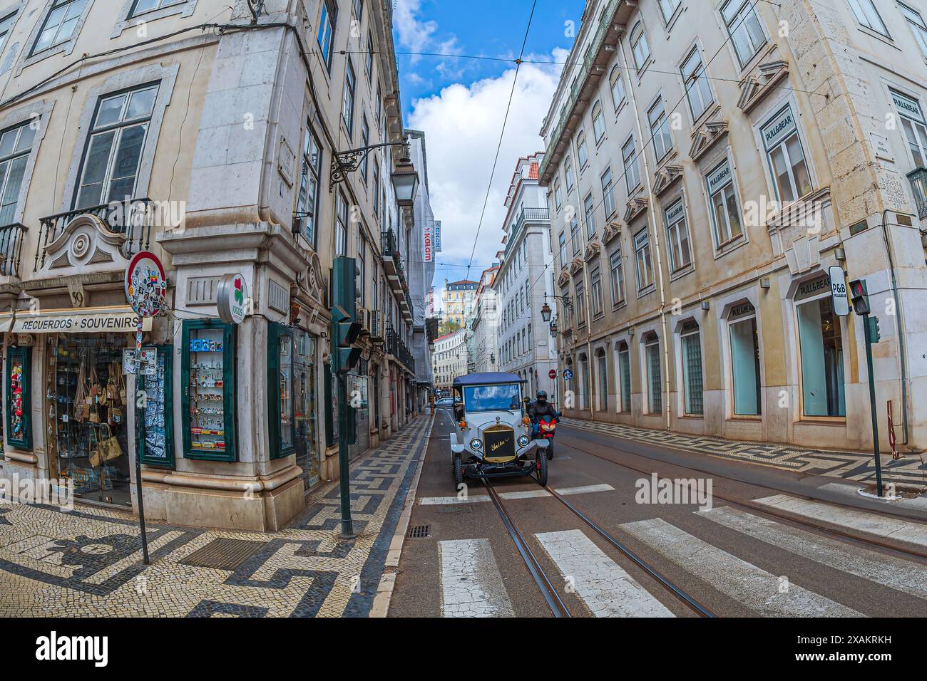 LISSABON, PORTUGAL - 8. APRIL 2024: Ein lustiges Elektroauto namens Tuk-Tuk-Auto, das ein Oldtimer symbolisiert, der für den Transport von Touristen auf der Stadtstraße verwendet wird Stockfoto