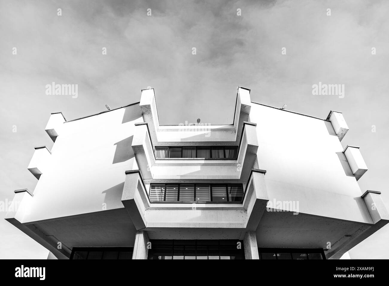 Architektonisches Detail aus einem weißen modernen Betongebäude mit rechteckigen Details vor dem blauen Himmel, modernistisches Architekturfragment. Stockfoto