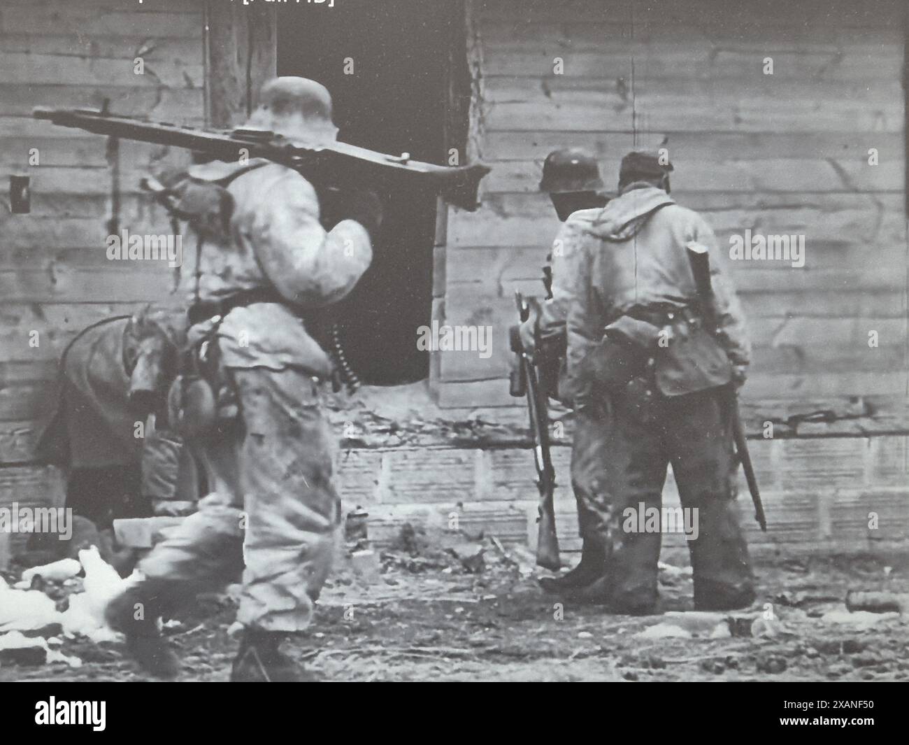 2. Weltkrieg Schwarzweißfoto Deutsche Soldaten suchen nach russischen Nachzüglern, nachdem sie im Winter 1944 in eine Stadt eingedrungen sind Stockfoto