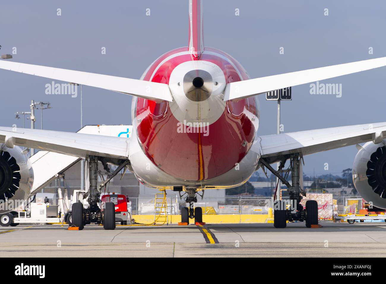 Abstrakte Ansicht der Heckflosse des Flugzeugs mit Außenansicht des Flughafens, Düsenmotoren, Flugbenzin auf der Piste, Flughafen Tullamarine, Melbourne. Stockfoto