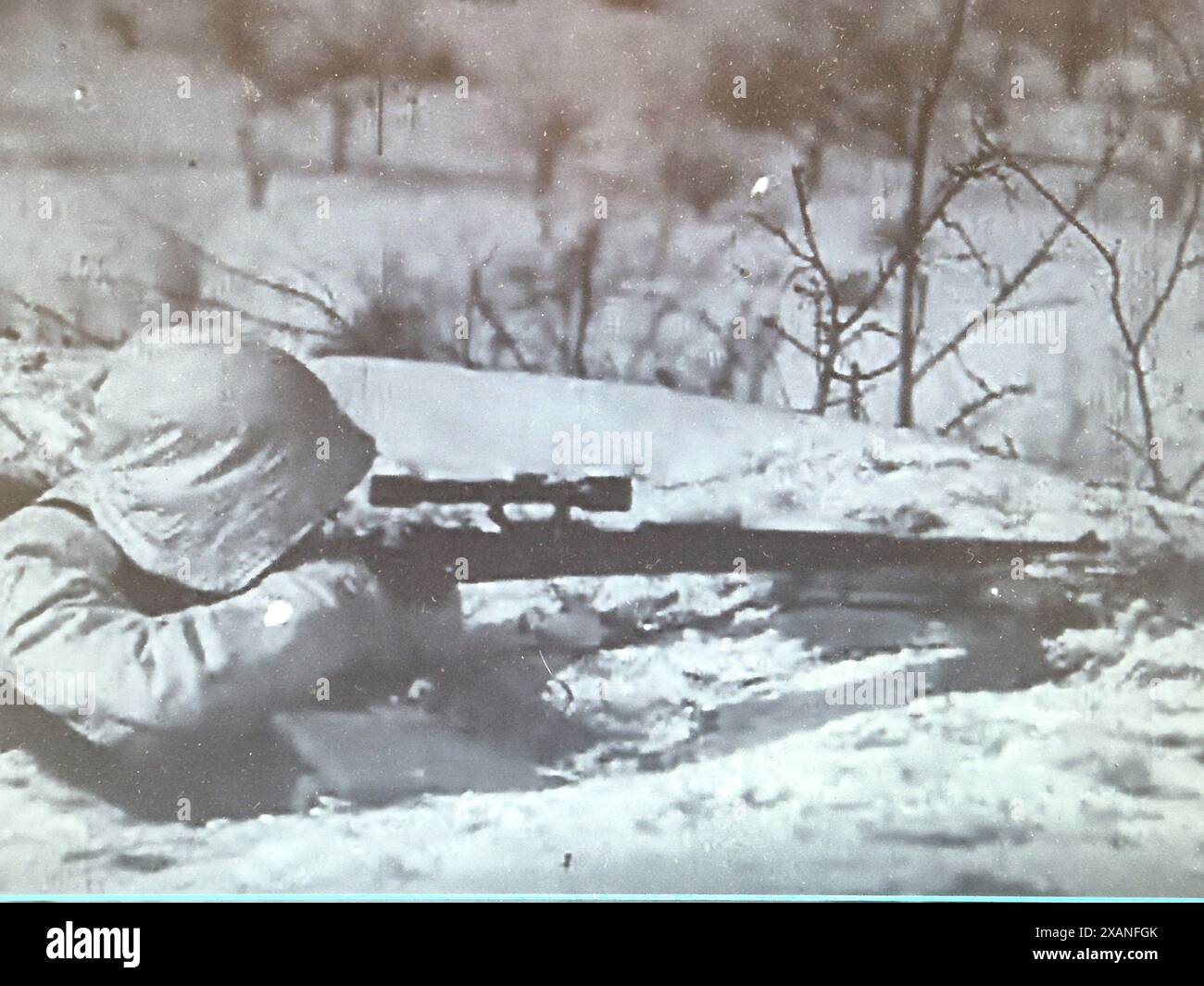 Screenshot des Zweiten Weltkriegs in Schwarzweiß. Deutscher Soldat mit Scharfschützengewehr in Schnee Camo während des Winters 1941/42 an der russischen Front. Stockfoto