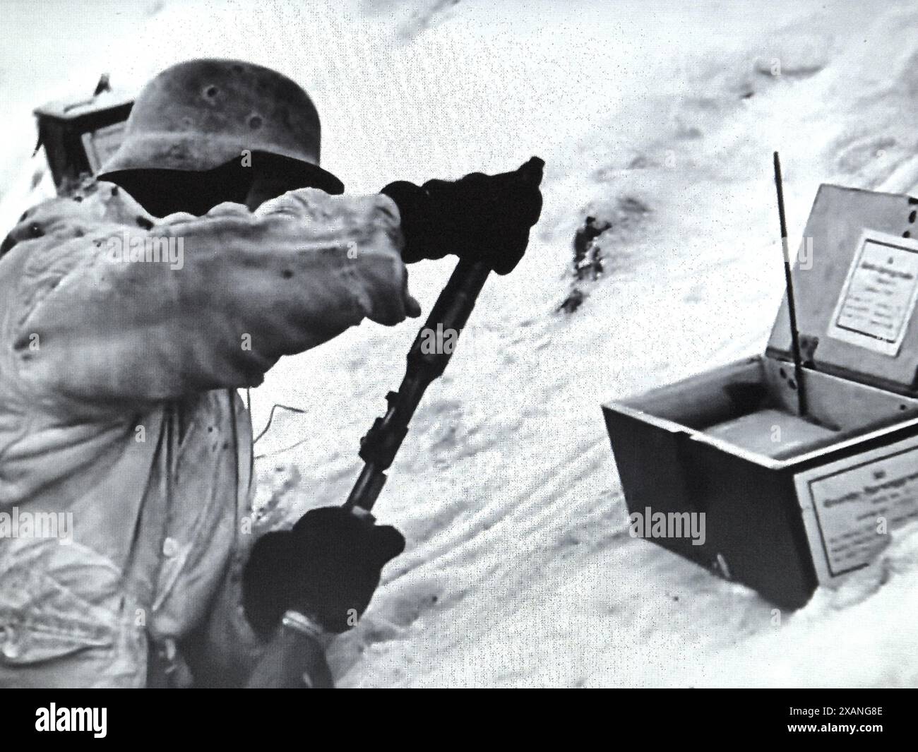WW2 Screen B&W noch deutscher Soldat in Snow Camo Parka lädt im Winter 1942/43 eine Gewehrgranate an der russischen Front Stockfoto