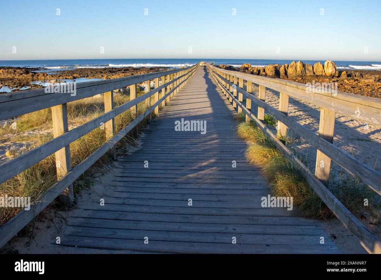 Holzweg mit Zaun zum Strand. Der Fußweg am Meer am Morgen. Reise- und Gehkonzept. Landschaft des Jakobsweges auf dem Atlantischen Ozean. Stockfoto