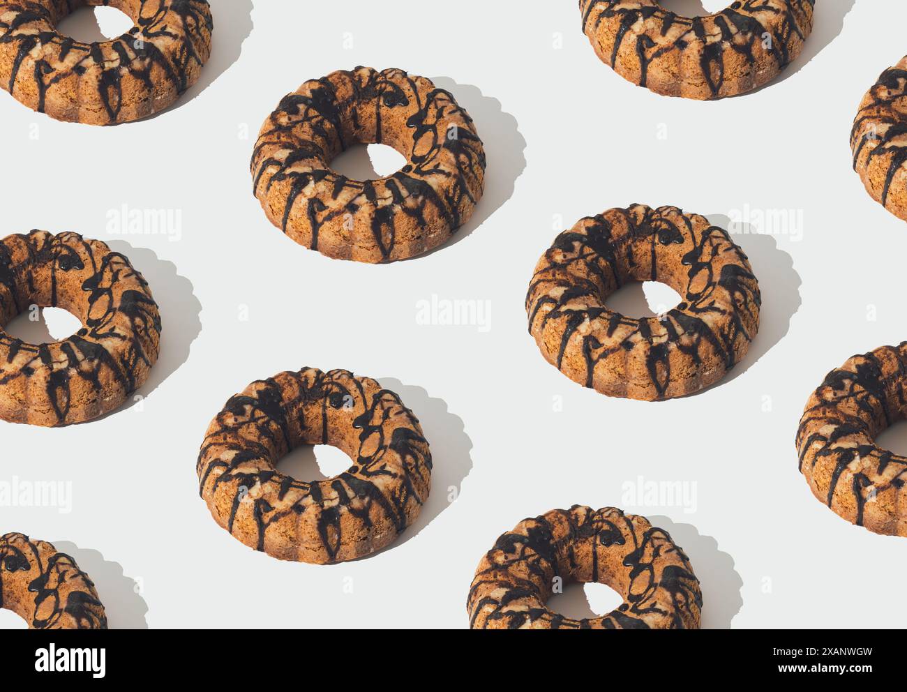 Kreatives trendiges Lebensmittelmuster aus köstlichem Kuchen mit Schokoladenbelag auf weißem Hintergrund. Minimales süßes Dessertkonzept. Tortenästhetik. Stockfoto