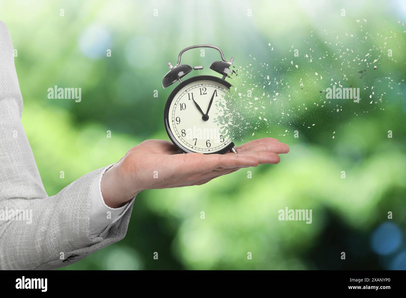 Die Zeit wird knapp. Frau mit auflösendem Wecker auf verschwommenem Hintergrund, Nahaufnahme Stockfoto