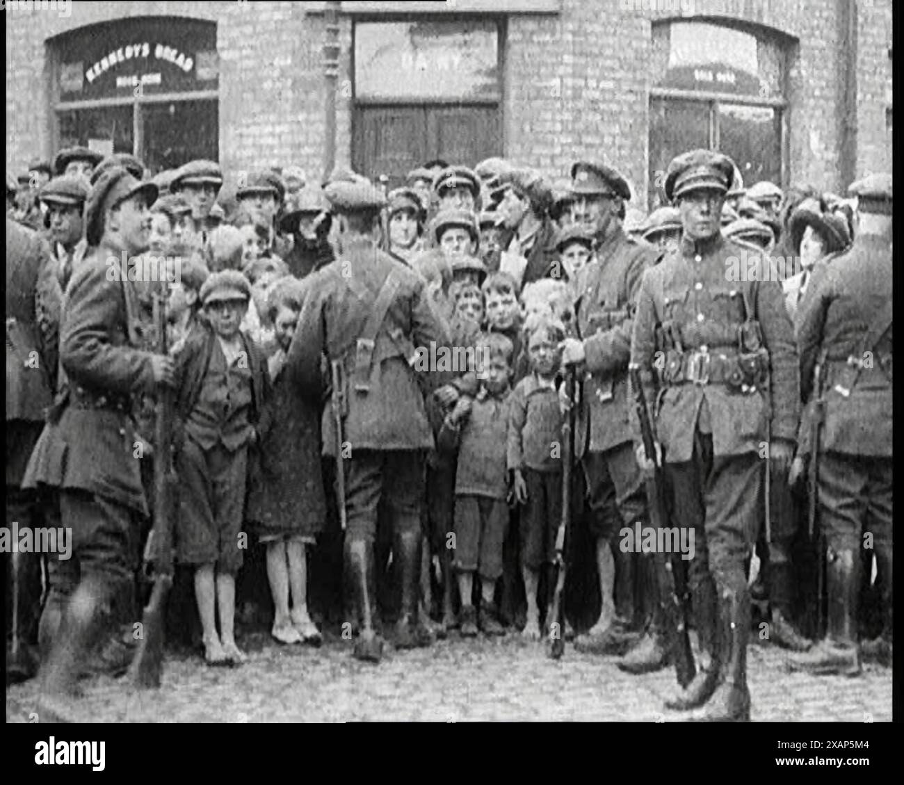 Soldaten, die Kinder in Dublin zurückhalten, 1922. Aus "Time to Remember - Sitting still and going Slow", 1922 (Reel 4); ein Überblick über die Ereignisse im Jahr 1922 einschließlich irischer Probleme, Krieg zwischen Griechenland und der Türkei und Entwicklungen in der Luftfahrt und im Radio. Stockfoto