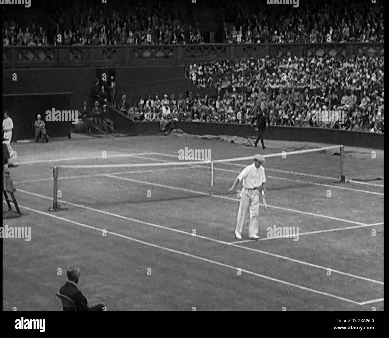 Zwei männliche Zivilisten, die ein Tennisspiel im Centre Court im All England Lawn Tennis and Croquet Club in Wimbledon spielen, vor einem großen Publikum, 1920er Jahre Aus „Time to Remember – Teenage Flapper“, 1920er Jahre (Walze 3); ein Dkumentary über das Leben von Frauen in den 1920er Jahren – großartiger Kommentar von Joyce Grenfell. Stockfoto