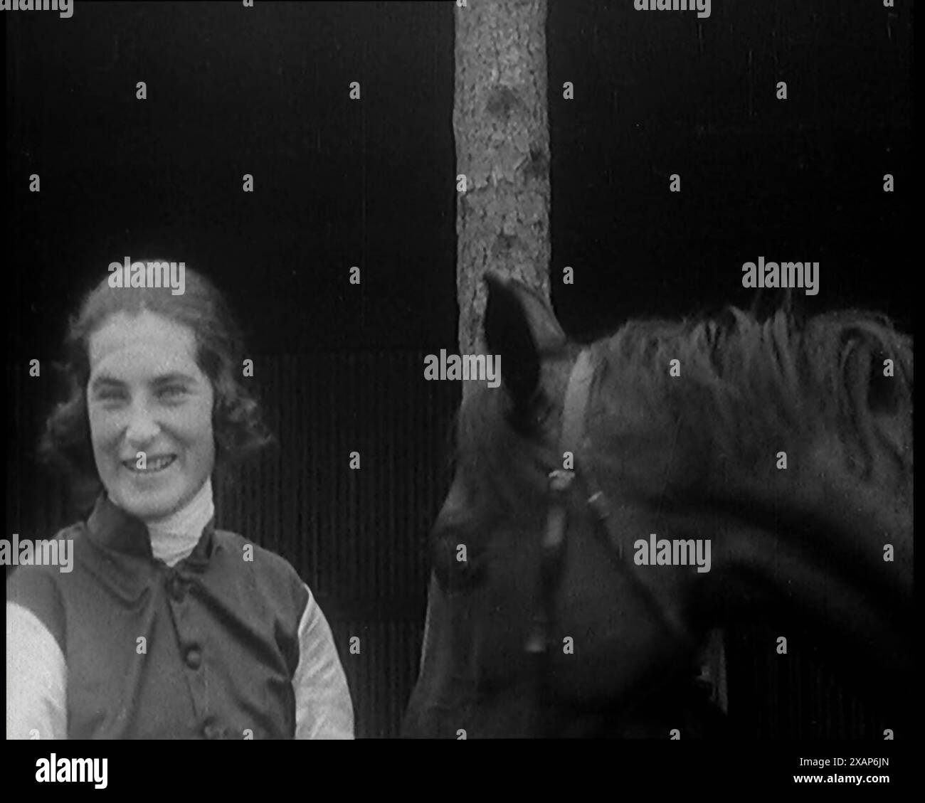 Eine weibliche Zivilist, die ein Jockeys Outfit trägt, ihren Hut vor ihrem Pferd entfernt und die Kamera anlächelt, 1920er Jahre Aus „Time to Remember – Teenage Flapper“, 1920er Jahre (Walze 3); ein Dkumentary über das Leben von Frauen in den 1920er Jahren – großartiger Kommentar von Joyce Grenfell. Stockfoto