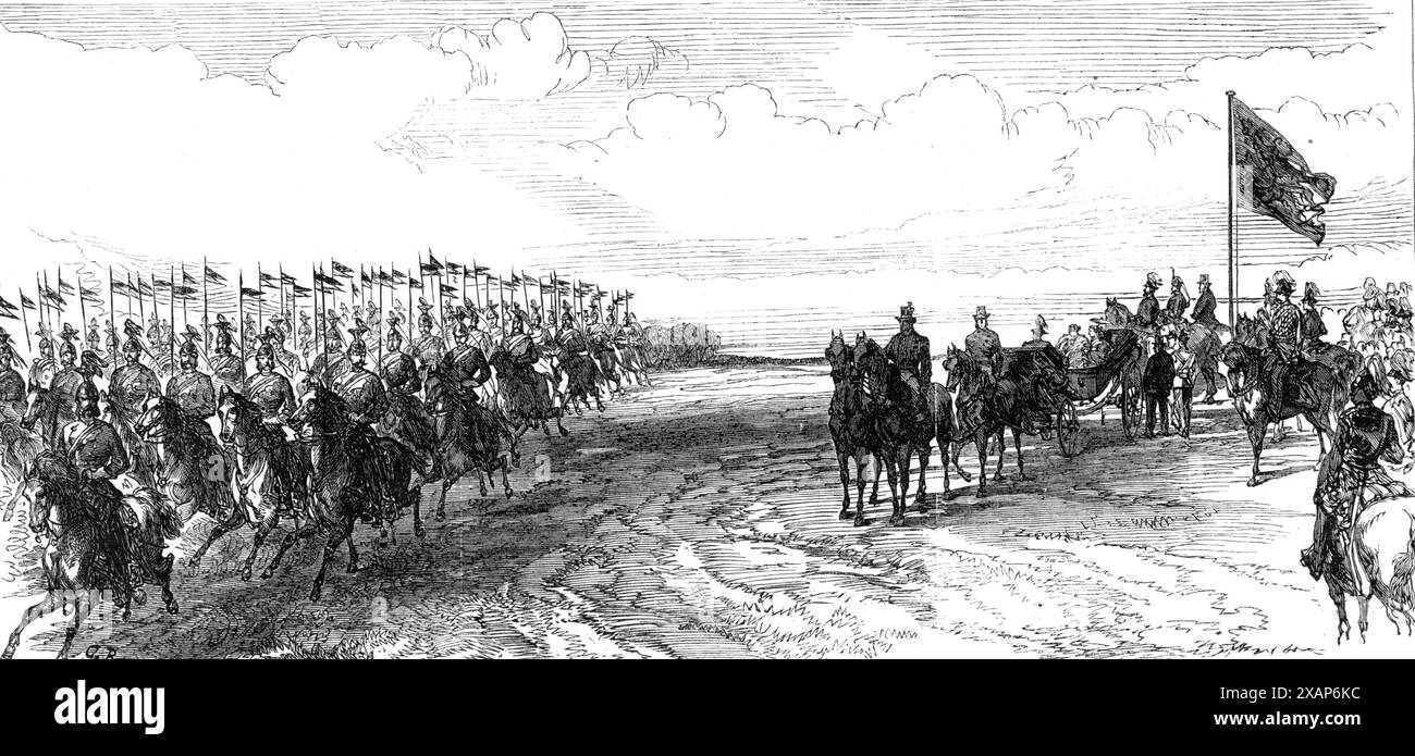 Besuch des Prinzen und der Prinzessin von Wales in Irland: Rezension im Phoenix Park [in Dublin]: Die 12. Lancers galoppieren vorbei, 1868. "...ein schönes militärisches Spektakel. Der Prinz und die Prinzessin kamen gegen ein Uhr auf den Boden; er war zu Pferd, und sie war in einer offenen Kutsche und vier... als sie hereinkamen, öffneten sich die Waffen mit einem königlichen Gruß, und „God Save the Queen“ von vielen Bands war über den Schreien der Menschen zu hören. Der Duke of Cambridge in der Uniform eines Feldmarschalls... ritt in der Nähe des Prinzen von Wales, der... die Uniform der 10. Husaren trug, und Prinz Teck, der seine trug Stockfoto