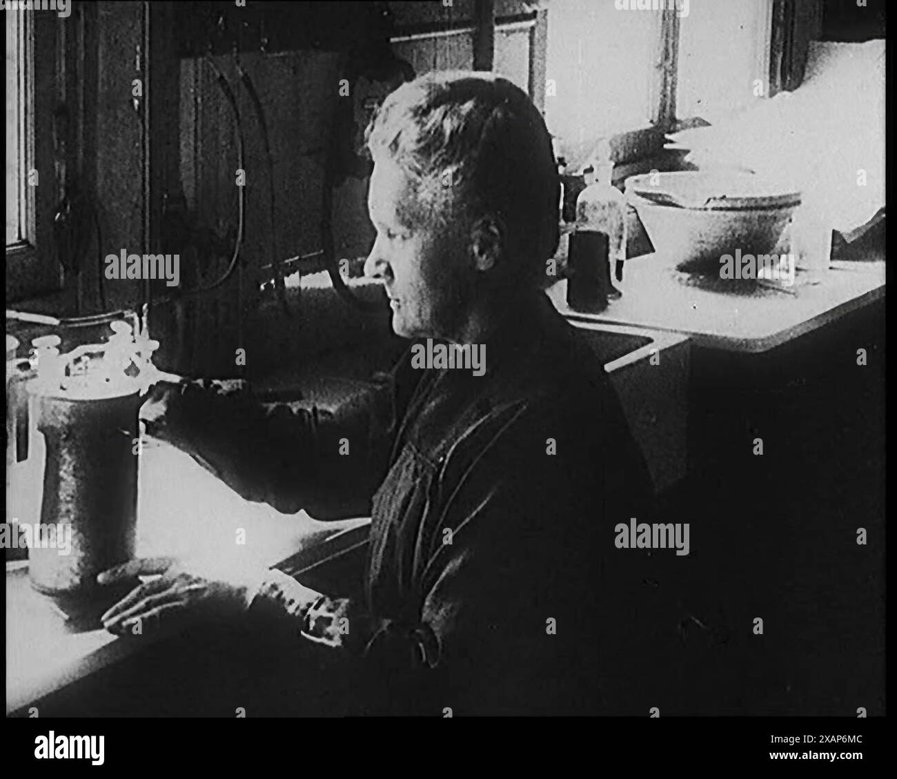 Marie Sklodowska Curie, die berühmte Physikerin und Chemikerin, in ihrem Labor, 1920er Jahre Aus „Time to Remember – Teenage Flapper“, 1920er Jahre (Reel 4); ein Dkumentary über das Leben von Frauen in den 1920er Jahren – großartiger Kommentar von Joyce Grenfell. Stockfoto