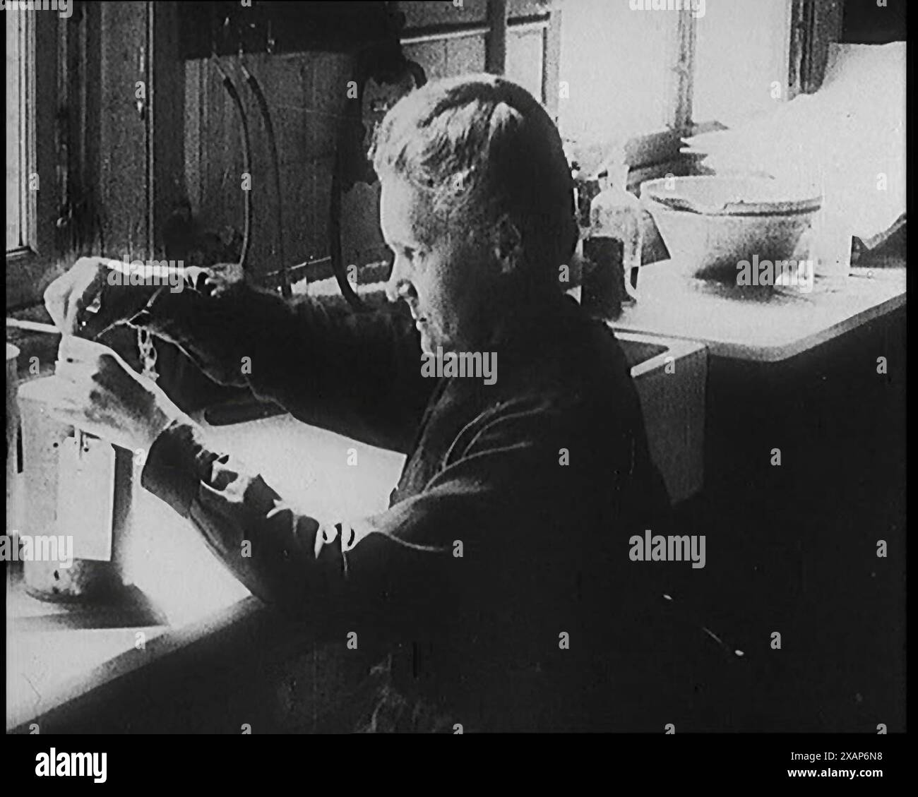 Marie Sklodowska Curie, die berühmte Physikerin und Chemikerin, in ihrem Labor, 1920er Jahre Aus „Time to Remember – Teenage Flapper“, 1920er Jahre (Reel 4); ein Dkumentary über das Leben von Frauen in den 1920er Jahren – großartiger Kommentar von Joyce Grenfell. Stockfoto