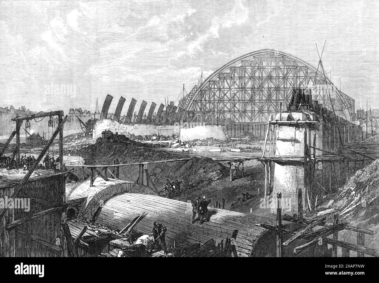 Werke des Midland Railway Terminus, Euston-Road, 1868. Bau des neuen Bahnhofs St. Pancras in London. Half Somers Town wurde abgerissen... der Metropolitan Tunnel der Midland Railway wird ein wichtiges Verkehrsmittel sein, da er Passagiere, die von Derby oder Manchester ankommen, direkt in das Herz der Stadt bringen wird...[die Ansicht zeigt] Ziegelsteinmauern, die den Tunnel im Vordergrund bedecken,... King's Cross nach rechts, und das Brill... auf der linken Seite, mit dem Kirchturm von Oakley-Square in der Ferne. Die enorme Spannweite der Eisenbögen, die das Dach des Bahnhofs bilden... füllt h aus Stockfoto