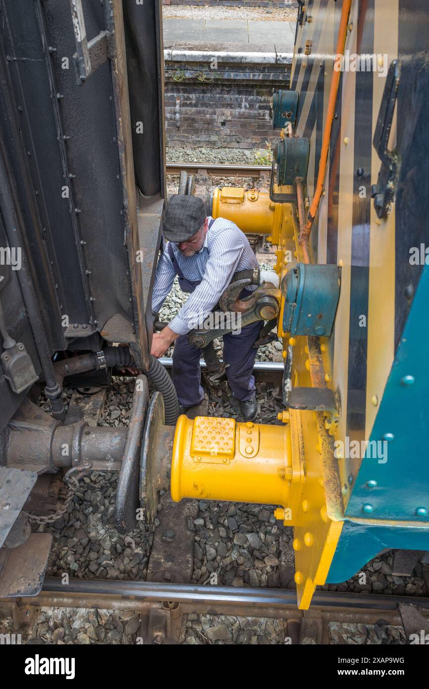 Zugführer koppeln die Passagierkarre an den restaurierten Dieselschlepper der Baureihe 08 am Bahnhof Llangollen an. Stockfoto