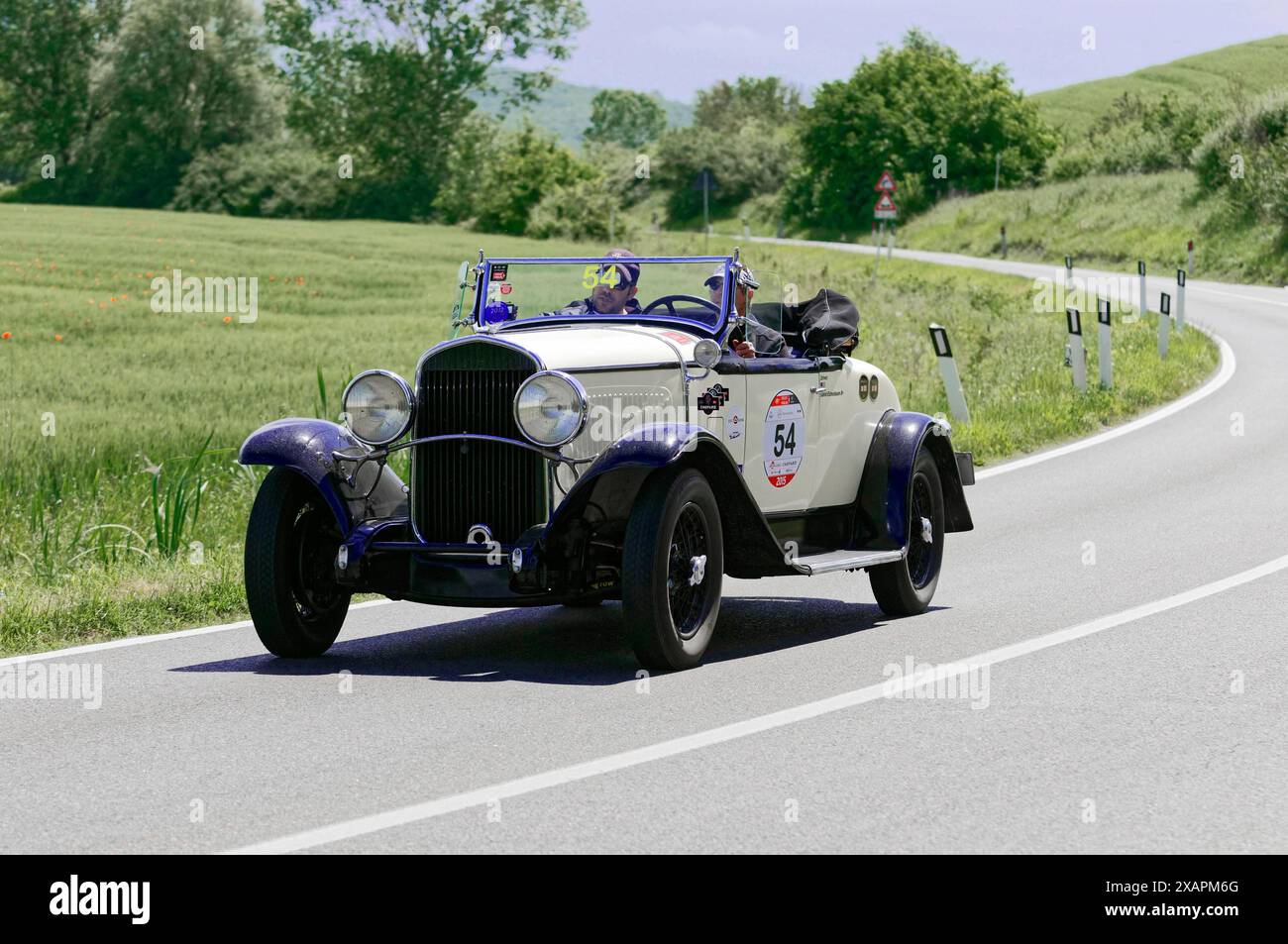 Weißer Oldtimer, der auf einer Landstraße fährt, umgeben von grüner Landschaft, Oldtimer, Autorennen, Mille Miglia, 1000 Miglia, 2015 Stockfoto
