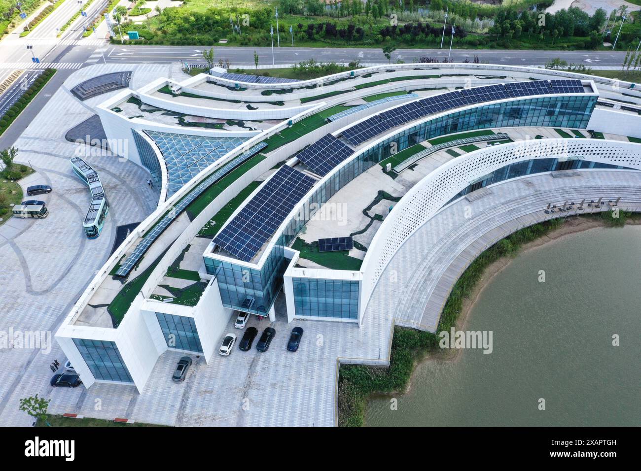 (240608) -- YANCHENG, 8. Juni 2024 (Xinhua) -- dieses am 6. Juni 2024 aufgenommene Luftdrohnenfoto zeigt eine Solar-Photovoltaikanlage auf dem Dach eines Gebäudes in einem Industrieforschungsinstitut mit niedrigen Kohlendioxidemissionen in Sheyang, Yancheng, ostchinesischer Provinz Jiangsu. Yancheng liegt an der Küste des Gelben Meeres und verfügt über die längste Küste und das größte Meeresgebiet der ostchinesischen Provinz Jiangsu. Es ist reich an Küstenwindenergie, Sonnenenergie und Biomasse, mit einer durchschnittlichen jährlichen Windgeschwindigkeit von mehr als 7,6 Metern pro Sekunde bei 100 Metern Höhe und einem durchschnittlichen jährlichen Sonnenschein Stockfoto