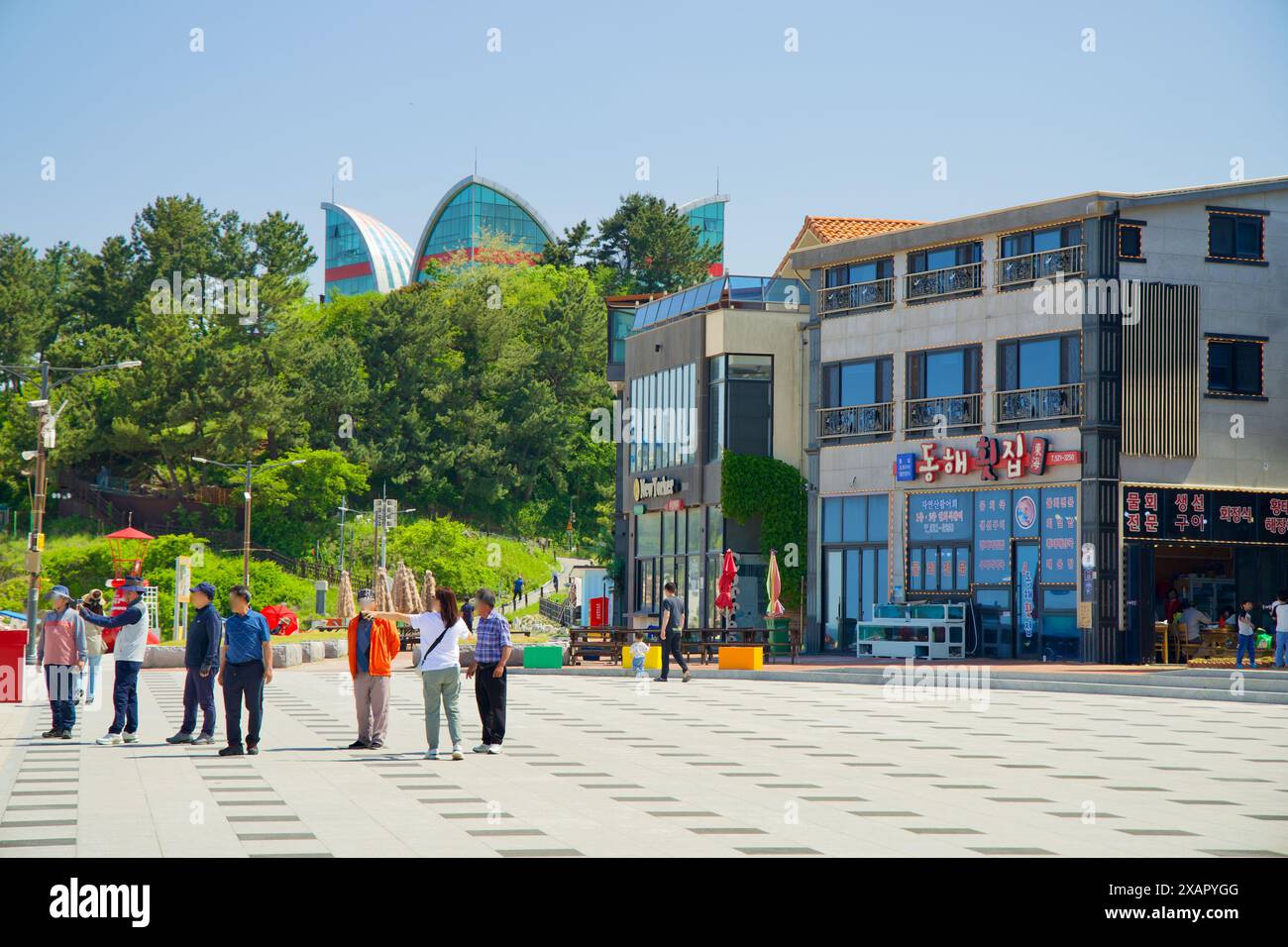 Donghae City, Südkorea - 18. Mai 2024: Eine Gruppe von Touristen erkundet den pulsierenden Platz in der Nähe von Chuam Beach mit Geschäften und Cafés in der Gegend und Stockfoto