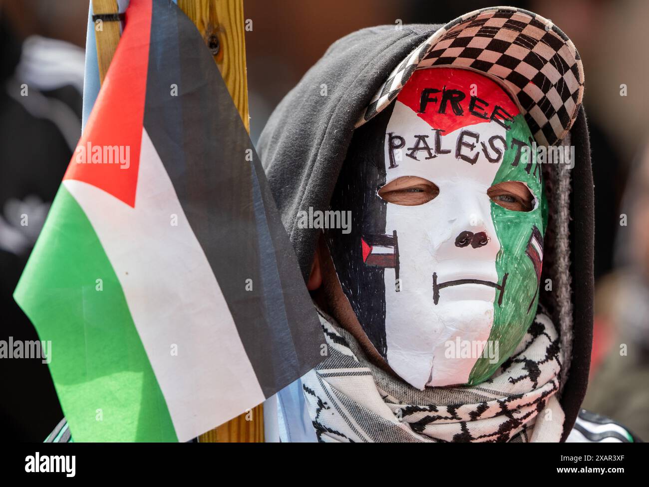 Maskierter Pro-Palästina-Unterstützer. Palästina Gaza-Krieg Proteste in Manchester Großbritannien. Demonstranten marschierten vom St Peter's Square zur Manchester University, wo Studenten das Whitworth-Gebäude besetzten und ein Zeltlager auf dem Campus der University of Manchester aufbauten, um gegen die Kontakte der Universität mit Israel zu protestieren. Auf den Bannern wurden Nachrichten geschrieben, in denen Großbritannien aufgefordert wurde, Israel nicht mehr zu bewaffnen, und die Wähler, bei den bevorstehenden Wahlen im Vereinigten Königreich nicht für Rishi Sunak und Keir Starmer zu stimmen. Manchester UK>Bild: Garyroberts/worldwidefeatures.com Stockfoto