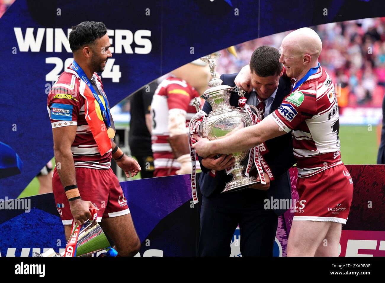 Matt Peet (Mitte), Cheftrainer der Wigan Warriors, feiert mit den Spielern Bevan French (links) und Liam Farrell nach dem letzten Pfiff im Finale des Betfred Challenge Cup im Wembley Stadium, London. Bilddatum: Samstag, 8. Juni 2024. Stockfoto