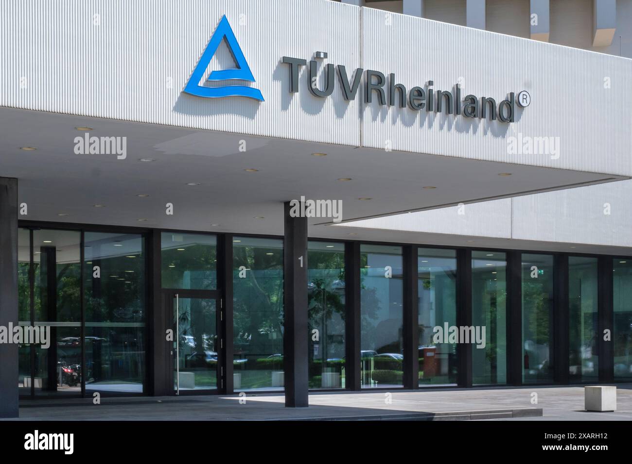 Eingang zum Hauptsitz mit TÜV Rheinland Logo Stockfoto