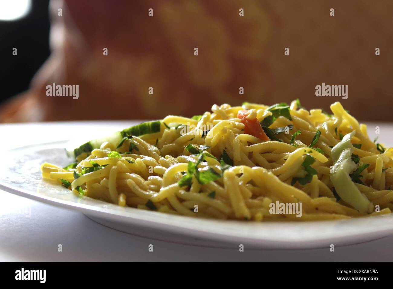 Indonesische gebratene Nudeln, Bami Goreng, mie Goreng auf einer weißen Platte mit selektivem Fokus und Bokeh Hintergrund. Stockfoto