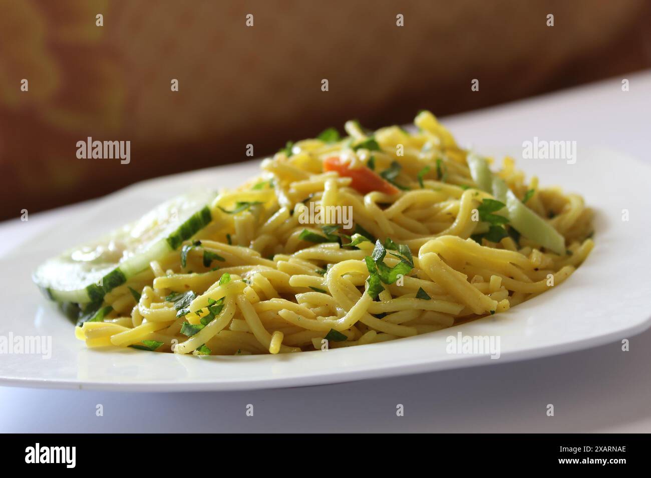 Bami Goreng, mie Goreng auf einer weißen Platte mit selektivem Fokus. Indonesische gebratene Nudeln mit Bokeh-Hintergrund. Stockfoto