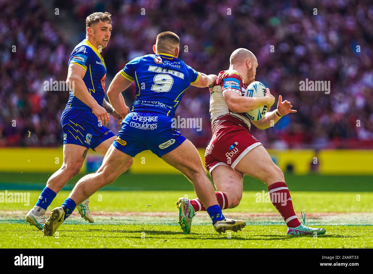 Wembley, London, Großbritannien. Juni 2024. Das Finale des Betfred Challenge Cup Rugby: Warrington Wolves vs. Wigan Warriors im Wembley Stadium. Liam Marshals Trikot wird von Danny Walker zurückgezogen, als er versucht, den Tackle zu machen. Credit James Giblin Photography/Alamy Live News. Stockfoto