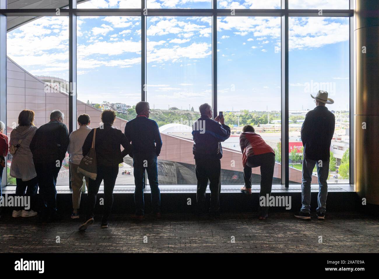 Leute, die aus dem Fenster auf dem Zwischengeschoss des BMO-Zentrums blicken. Calgary Alberta Kanada. Stockfoto