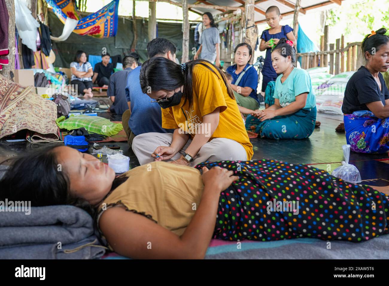 Ein Medizinstudent der zivilen Ungehorsambewegung sah, wie er sich darauf vorbereitete, einem Patienten im Kriegsflüchtlingslager eine Injektion zu geben. Flüchtlinge aus dem Bürgerkrieg in Myanmar haben in der Nähe der Grenze zu Thailand Zuflucht gefunden. Die Armee Myanmars hat Mörserangriffe und Luftangriffe auf Rebellenpositionen und zivile Siedlungen eingeleitet. Southern Territory Supportive Organization ist eine freiwillige medizinische Team-Organisation, die im August 2021 gegründet wurde. Sie gewährten VERTRIEBENEN, Kriegsflüchtlingen, Wanderarbeitern, revolutionären Kräften und Dörfern unter der Kontrolle der ethnischen Revolutionären Organisation kostenlose medizinische Behandlung. Stockfoto