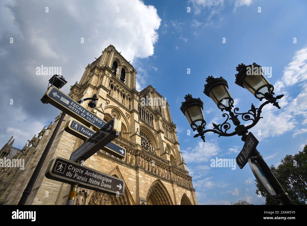 Schilder und Straßenlaternen an der Kathedrale Notre-Dame an einem Sommertag - Paris, Frankreich Stockfoto