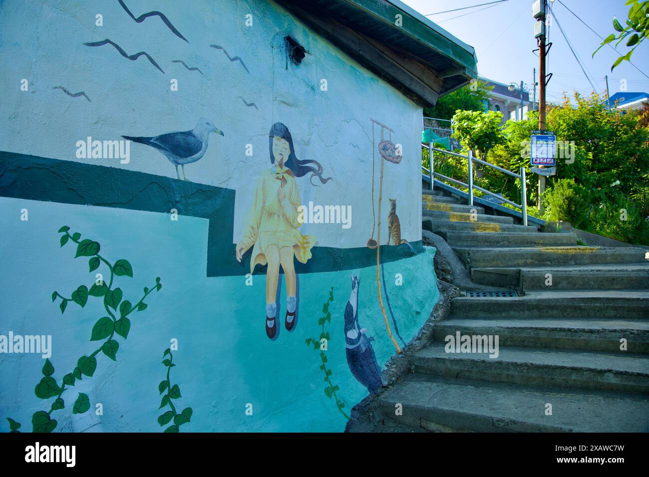 Donghae City, Südkorea - 18. Mai 2024: Ein bezauberndes Wandgemälde mit einem Mädchen, einer Katze und einer Möwe ziert eine Wand an der Nongoldam Street und fügt einen Wimsi hinzu Stockfoto