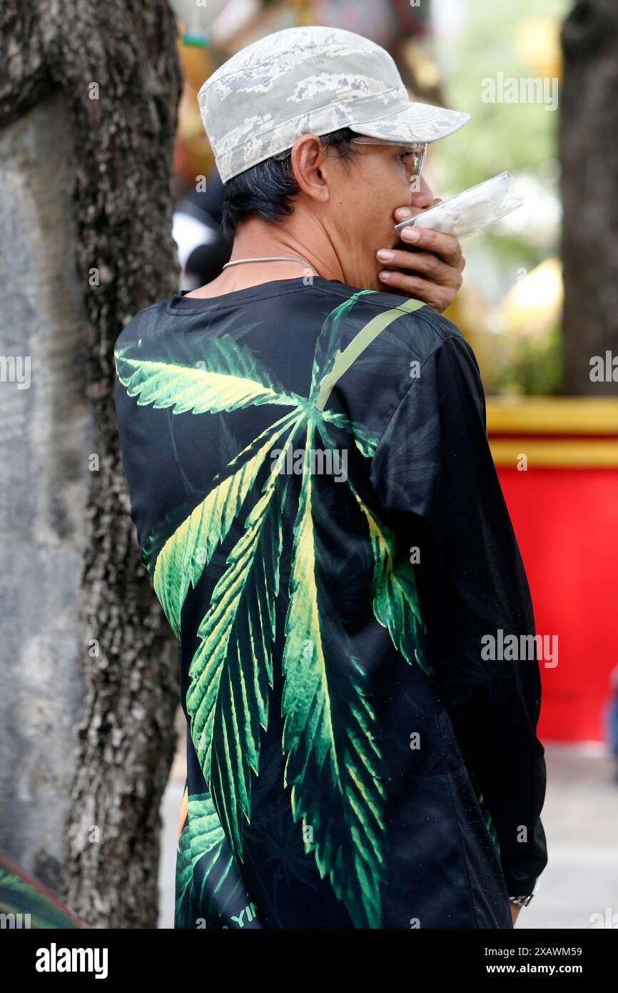 Bangkok, Thailand. Juni 2024. Ein Cannabisaktivist, der ein T-Shirt mit Cannabisblatt-Symbol während des Protestes vor dem Gebäude der Vereinten Nationen in Bangkok trug. Eine Gruppe von Cannabisaktivisten und -Unterstützern versammelte sich, um gegen die Möglichkeit der Wiederkriminalisierung von Cannabis zu protestieren, nachdem Cannabis in Thailand 2022 entkriminalisiert wurde. Die thailändische Regierung plant, das Land bis Ende 2024 wieder unter Strafe zu stellen. Quelle: SOPA Images Limited/Alamy Live News Stockfoto