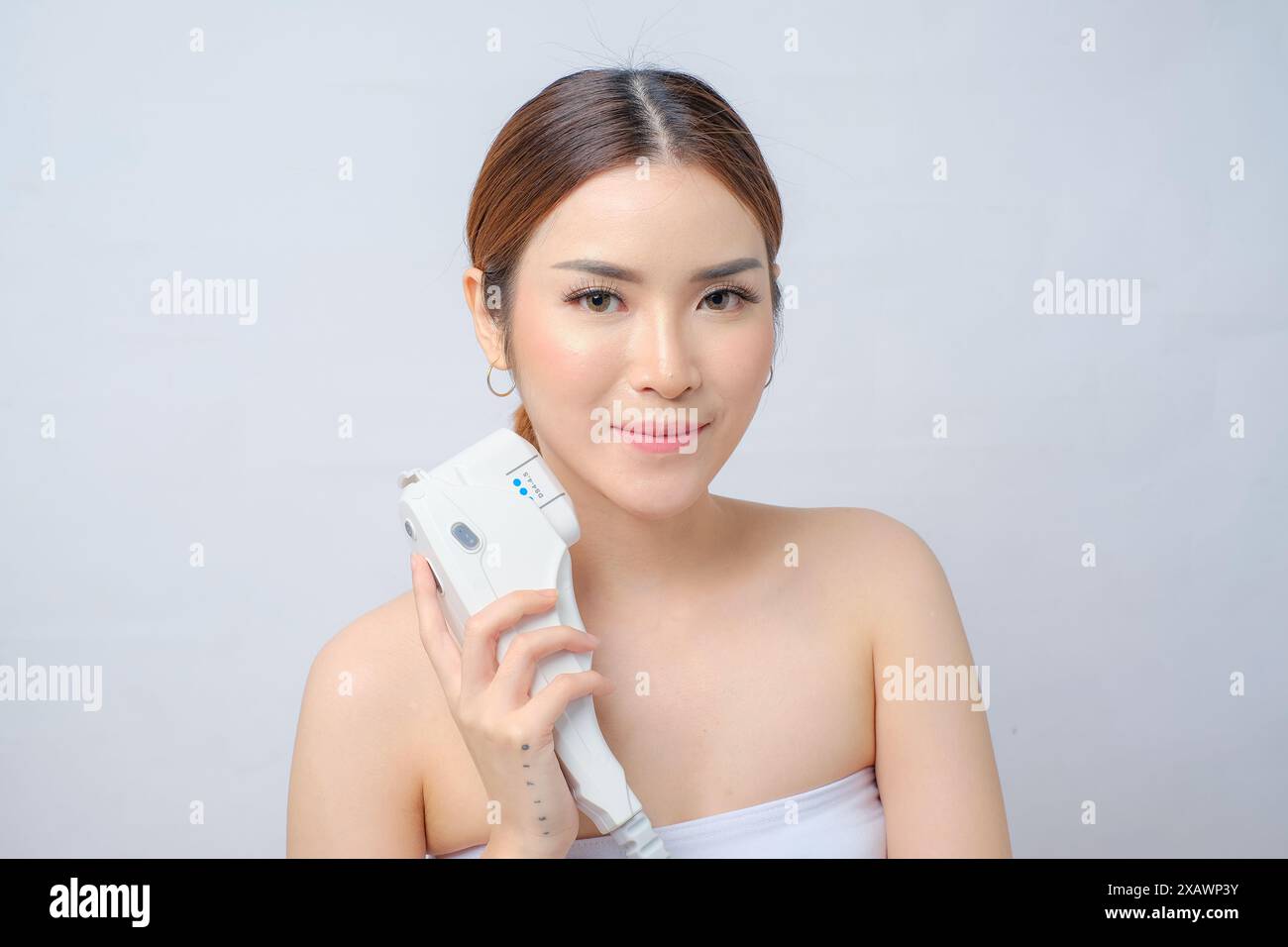 Radiant Asian Woman Getting Laser HIFU Skin Straffung Behandlung isolierter weißer Hintergrund Stockfoto