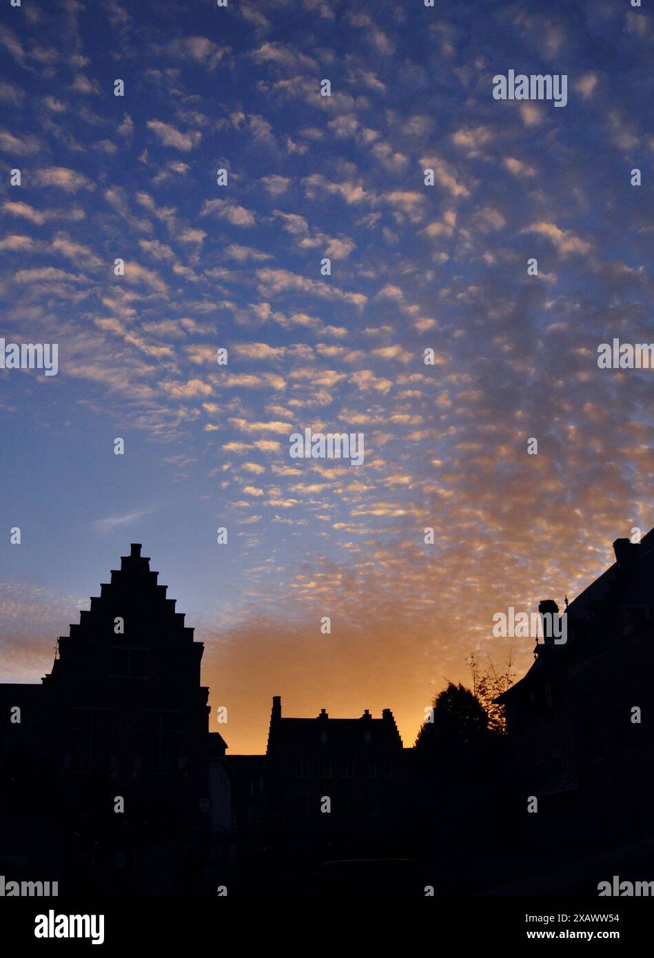 Ein atemberaubender Sonnenuntergang wirft Silhouetten typischer nordeuropäischer Häuser Stockfoto