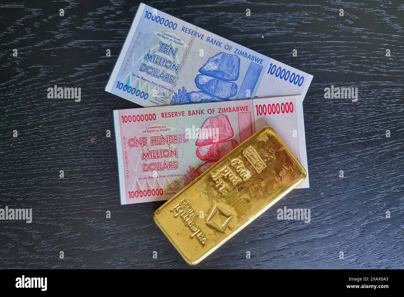 Stockholm, Schweden - 15. Mai 2024: Einhundert Millionen Dollar und zehn Millionen Dollar Banknoten von Simbabwe mit Goldbarren. Stockfoto